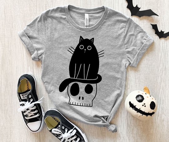 Halloween Black Cat Having An Existential Crisis Sitting On Skull Unisex T-Shirt, Raglan, Or Crewneck Sweatshirt. Men Women Tee